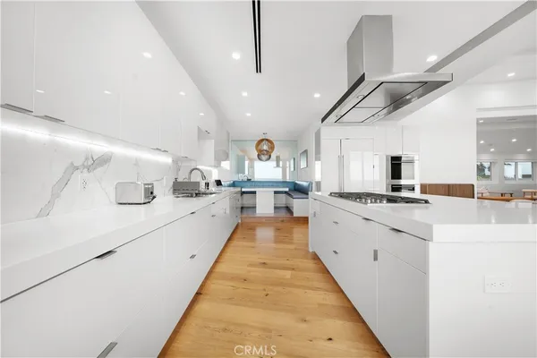 a kitchen with stainless steel appliances a stove a sink a microwave a refrigerator and cabinets