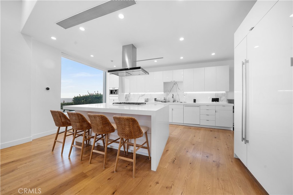 31654 Broad Beach Road Malibu, CA 90265 - Photo 23 of 75 a kitchen with stainless steel appliances a table chairs refrigerator and sink