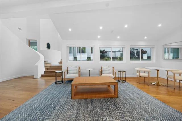 a living room with furniture kitchen view and a large window