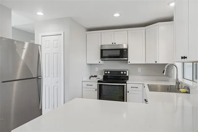 a kitchen with stainless steel appliances a refrigerator stove microwave and cabinets