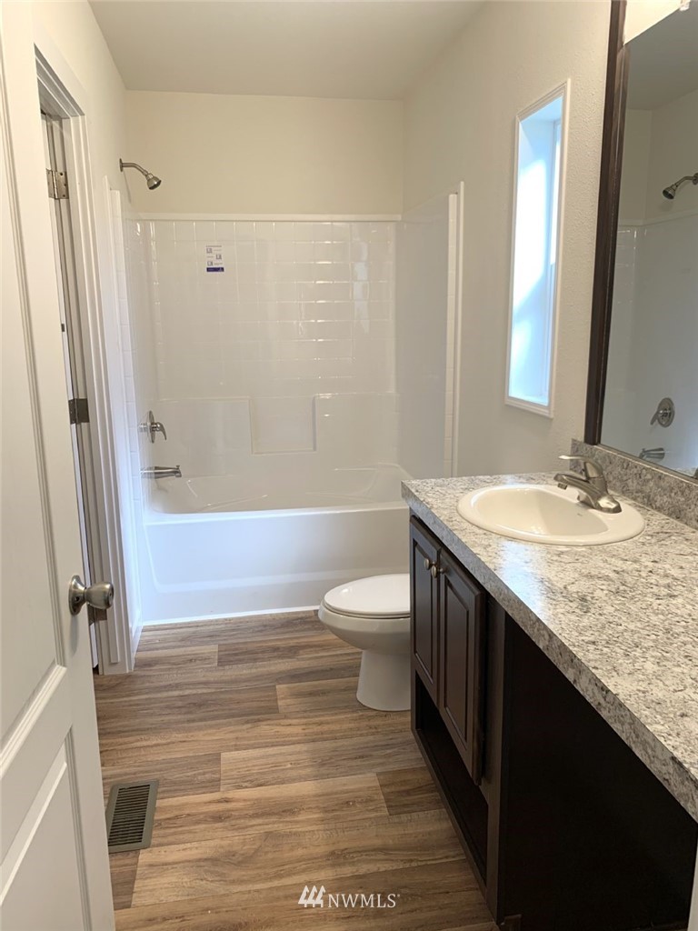 4590 Lake Terrell Road Ferndale, WA 98248 - Photo 12 of 25 a bathroom with a granite countertop sink toilet a mirror and shower