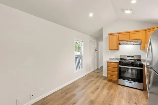 a kitchen with stainless steel appliances a stove a table and chairs