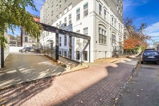 a view of a building with car parked on the road