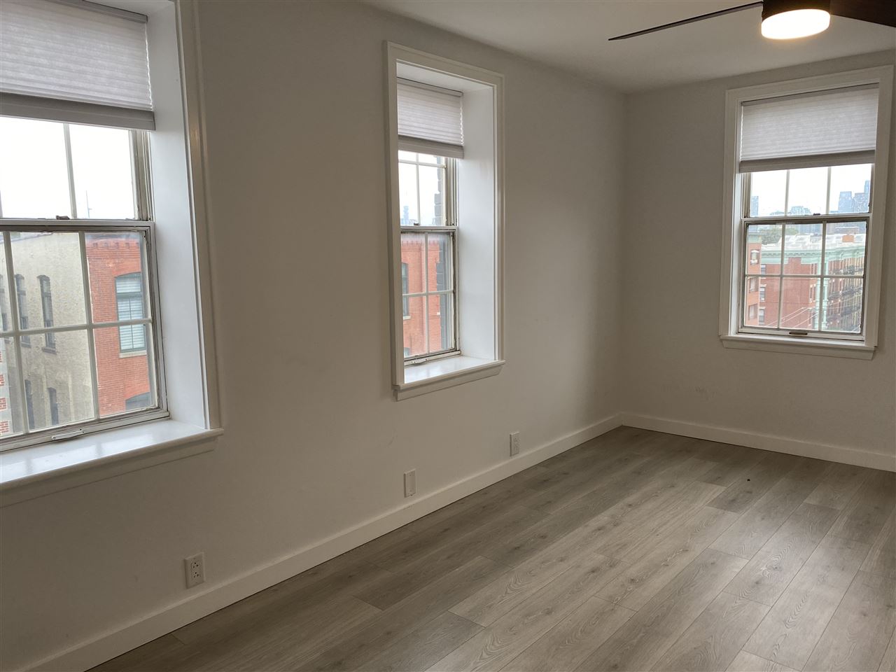 1024 Clinton Street, Unit 502 Hoboken, NJ 07030 - Photo 7 of 17 an empty room with wooden floor and windows