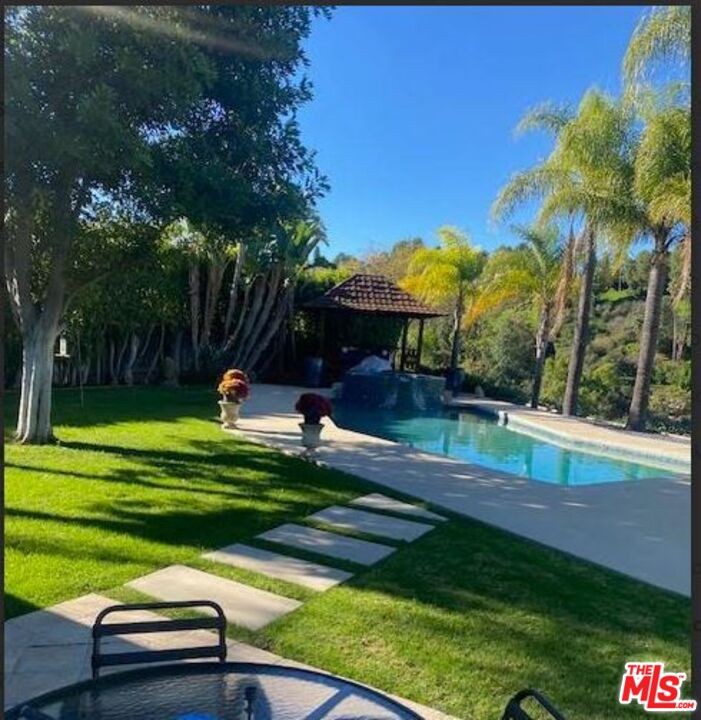 3761 Sheridge Drive Sherman Oaks, CA 91403 - Photo 2 of 3 a view of a table and chairs under an umbrella in front of house