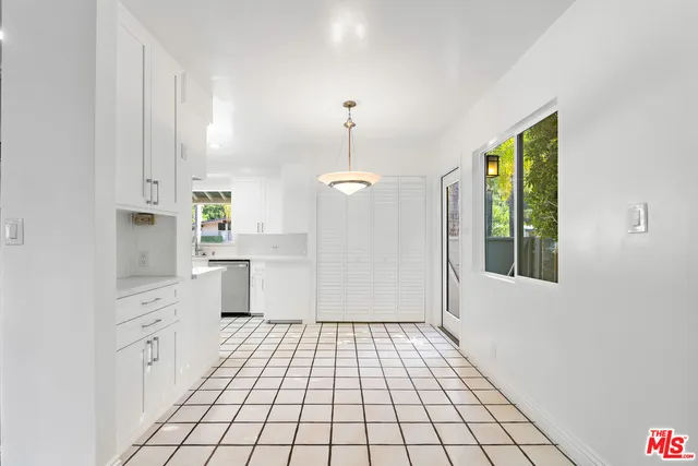 a kitchen with white cabinets a window a sink and a counter top space