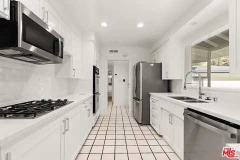a kitchen with a sink stainless steel appliances and cabinets
