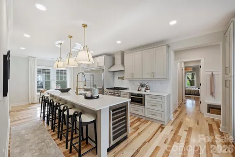 a kitchen with stainless steel appliances granite countertop a kitchen island a stove and a wooden floors