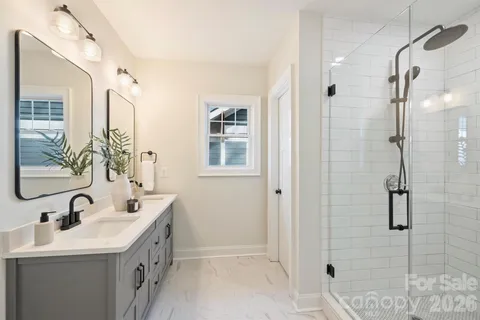 a bathroom with a double vanity sink a mirror and shower