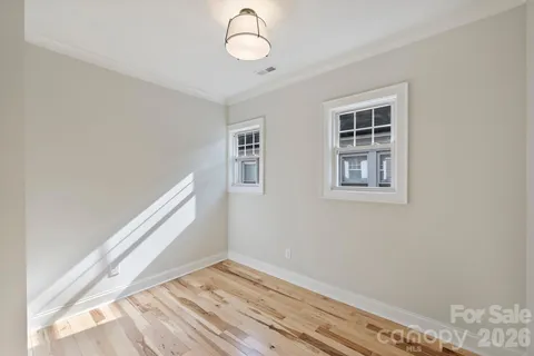 a view of room with window and wooden floor