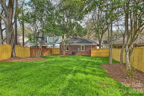 a view of a house with backyard and a tree