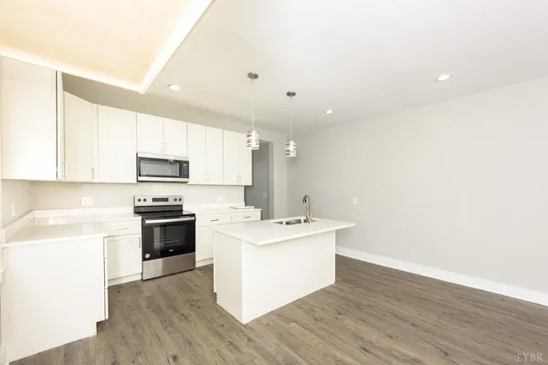 a kitchen with sink a mirror and cabinets