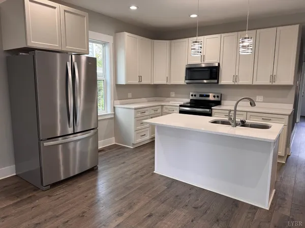 a kitchen with a sink cabinets and wooden floor