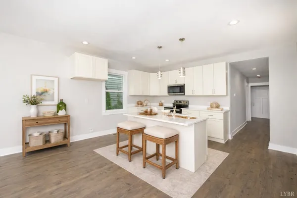 a kitchen with a sink a window a stove and white cabinets