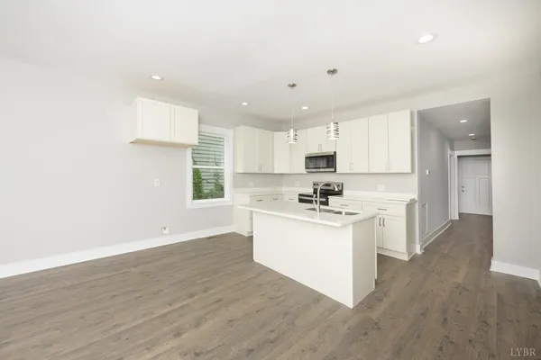 a kitchen with stainless steel appliances a sink stove and wooden floor