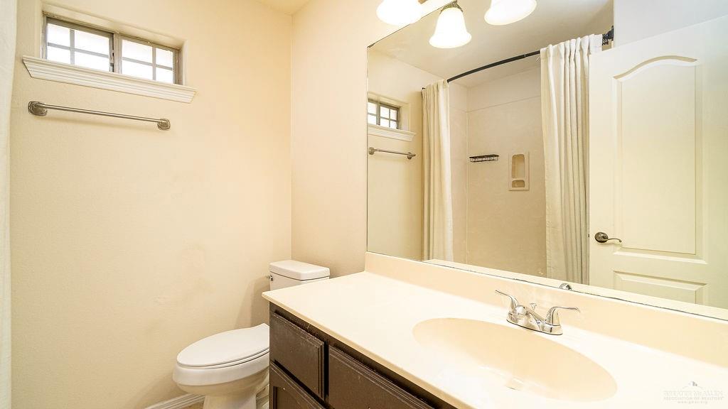 919 Hill Country Road Edinburg, TX 78539 - Photo 11 of 22 Bathroom with single vanity, integrated sink, and dark wood-finish cabinetry