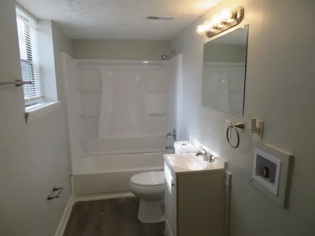 a bathroom with a granite countertop sink toilet and shower