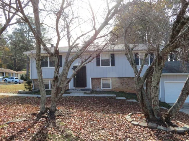 a house that has a tree in front of the house
