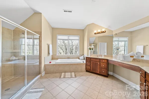 a spacious bathroom with a granite countertop double vanity and a mirror