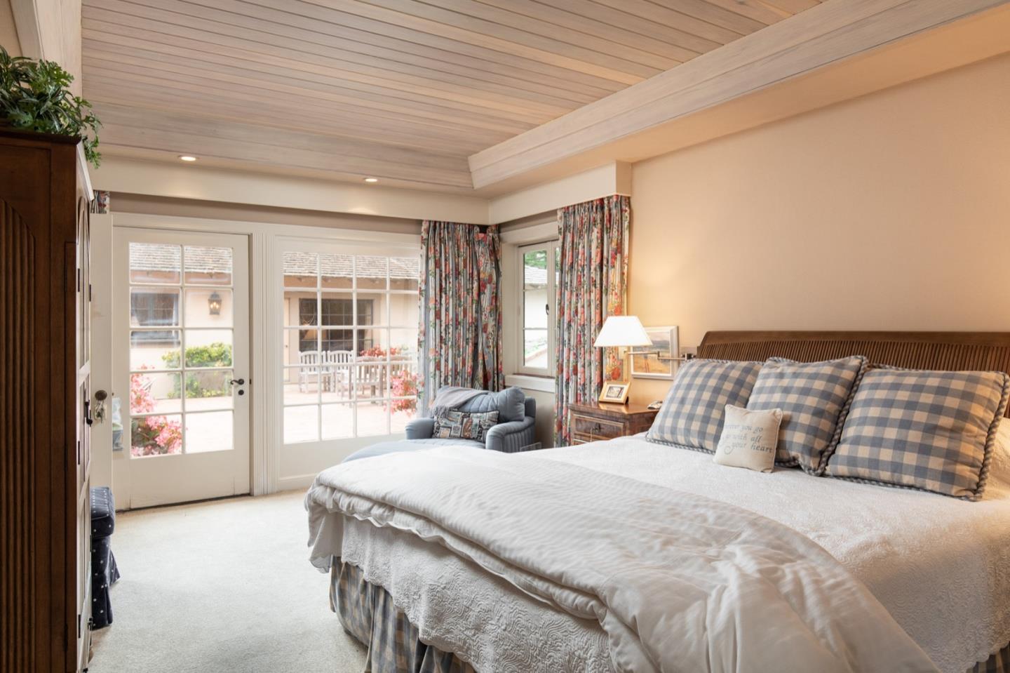 1427 Riata Road Pebble Beach, CA 93953 - Photo 13 of 24 a bedroom with a large bed and a large window