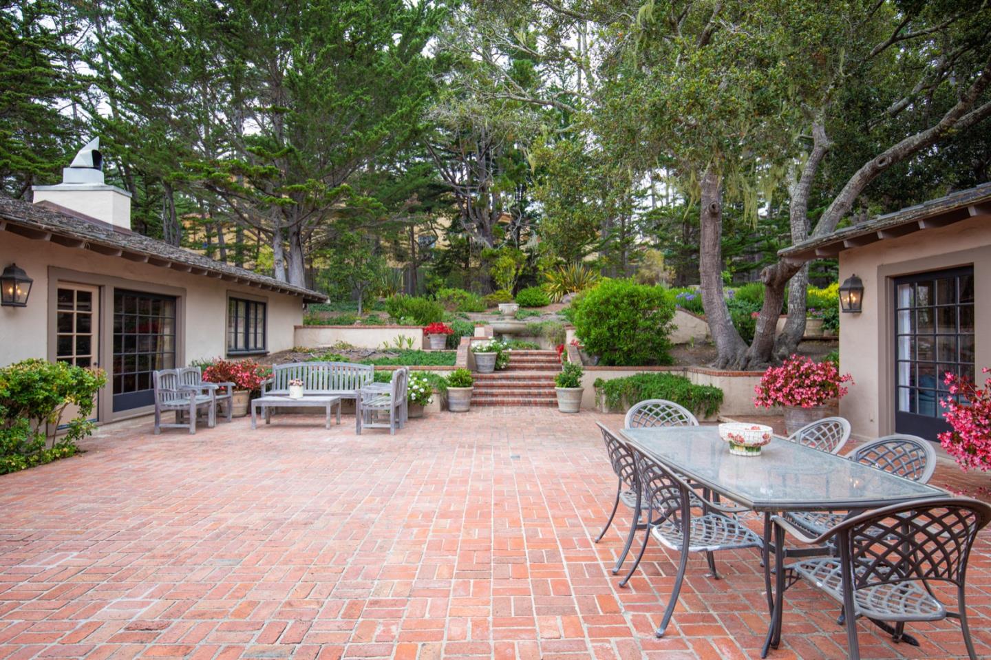 1427 Riata Road Pebble Beach, CA 93953 - Photo 17 of 24 a view of a chairs and table in backyard of the house