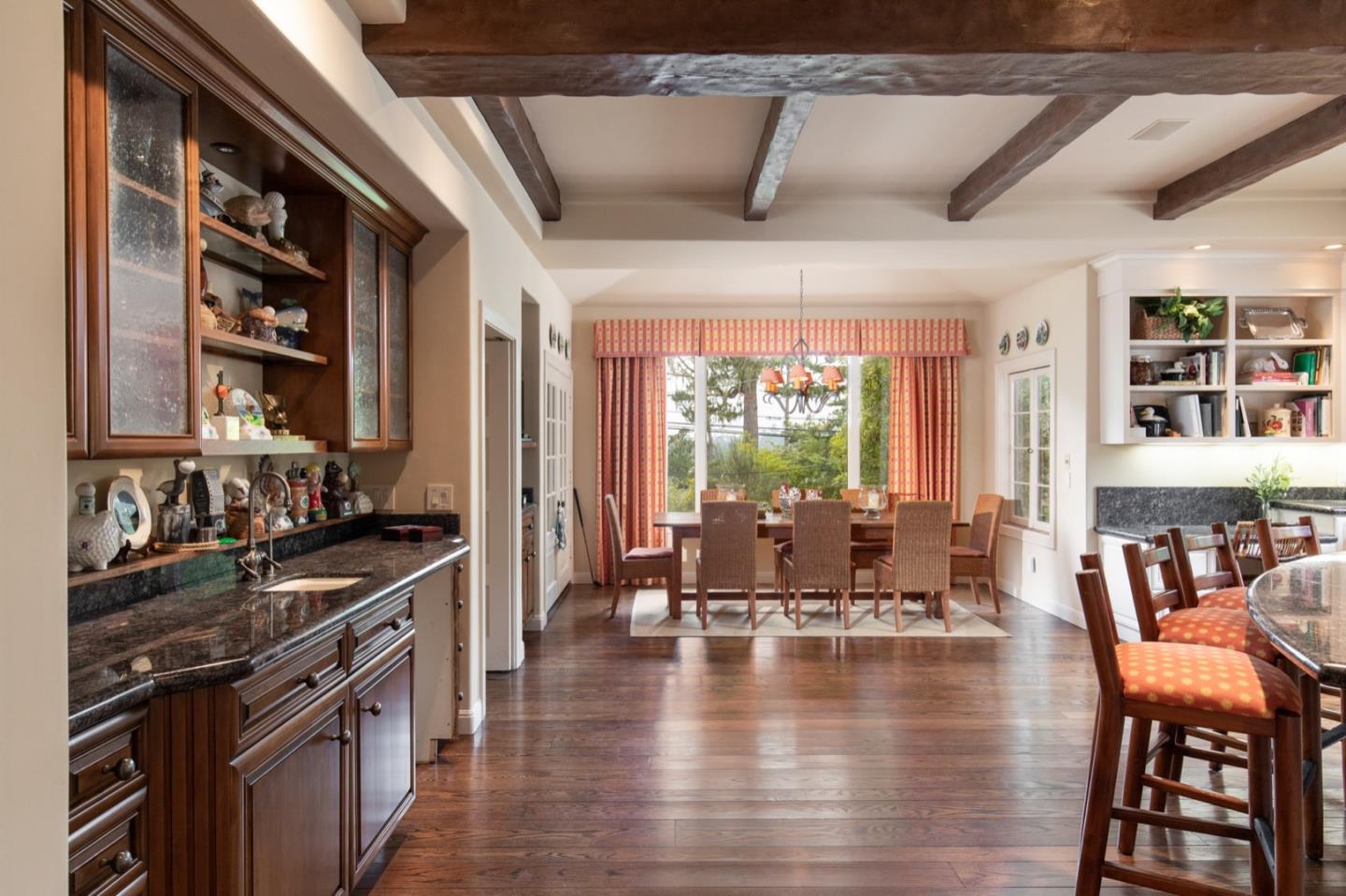 1427 Riata Road Pebble Beach, CA 93953 - Photo 8 of 24 a kitchen with stainless steel appliances granite countertop a stove top oven a dining table and chairs with wooden floor