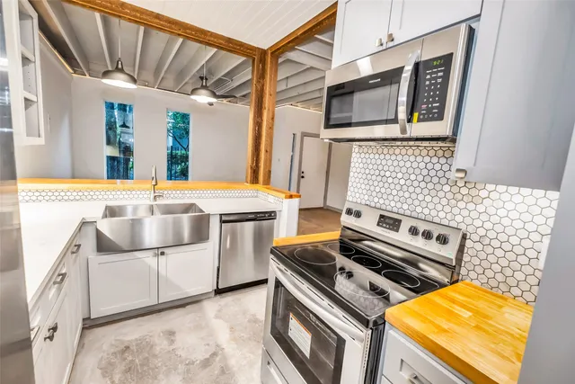 a kitchen with stainless steel appliances granite countertop a refrigerator and a stove