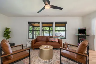 a living room with furniture a fireplace and a dining table with wooden floor