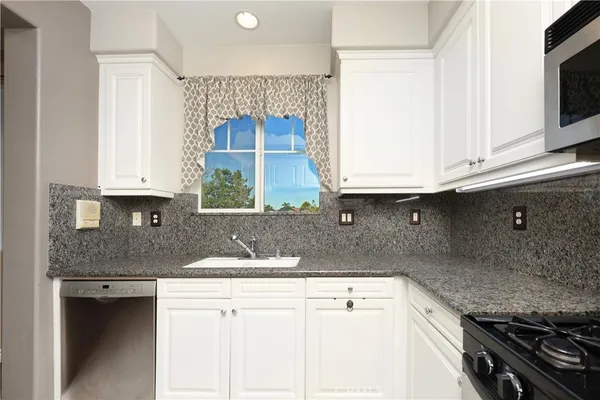 a kitchen with stainless steel appliances granite countertop a sink stove and microwave
