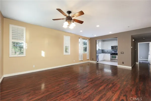 a view of an empty room with window and wooden floor