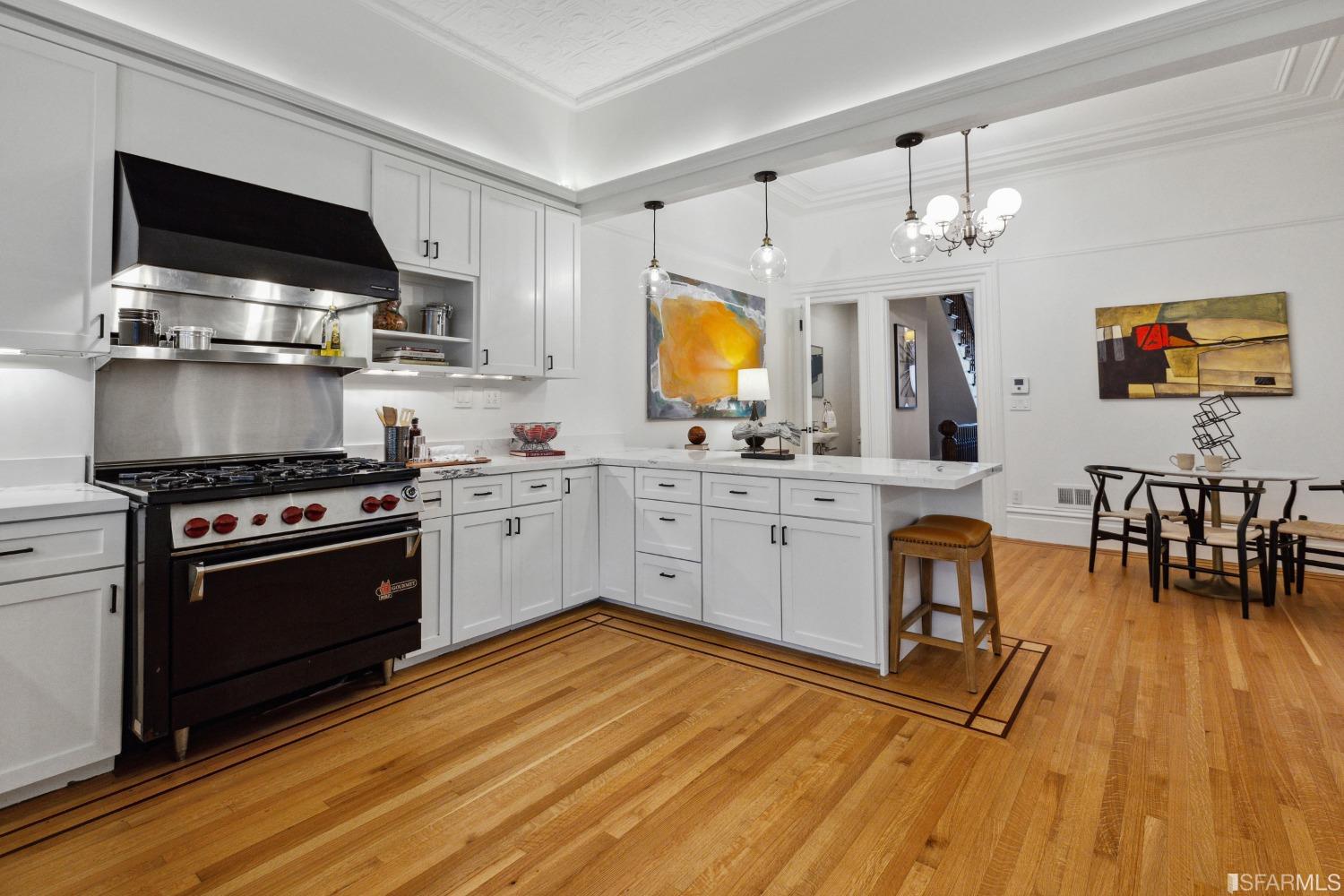 151 Broderick Street San Francisco, CA 94117 - Photo 13 of 39 a kitchen with stainless steel appliances a stove top oven a sink dishwasher and white cabinets with wooden floor
