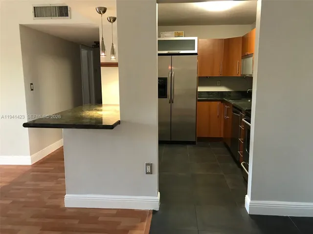 a kitchen with a refrigerator and a sink
