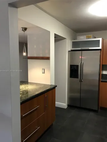 a kitchen with stainless steel appliances granite countertop a refrigerator and a sink