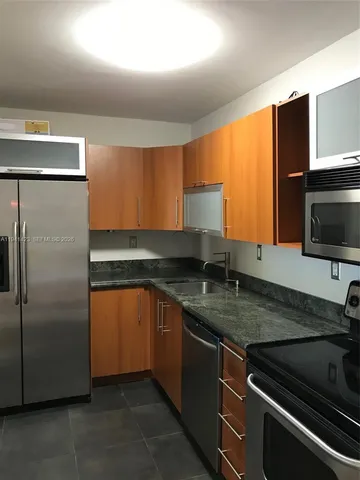 a kitchen with stainless steel appliances granite countertop a sink and a microwave