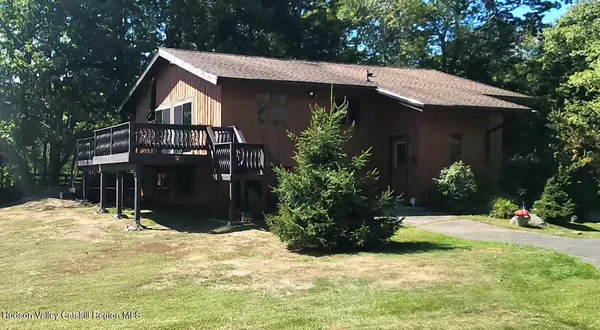 a view of a house with snow yard and covered with trees