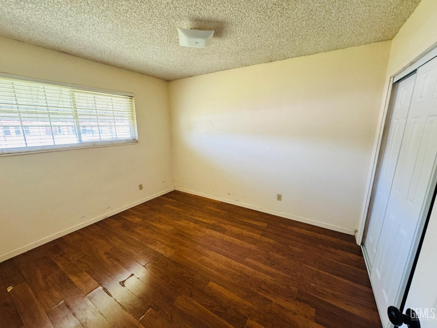 Undisclosed Address Delano, CA 93215 - Photo 7 of 14 an empty room with wooden floor and windows