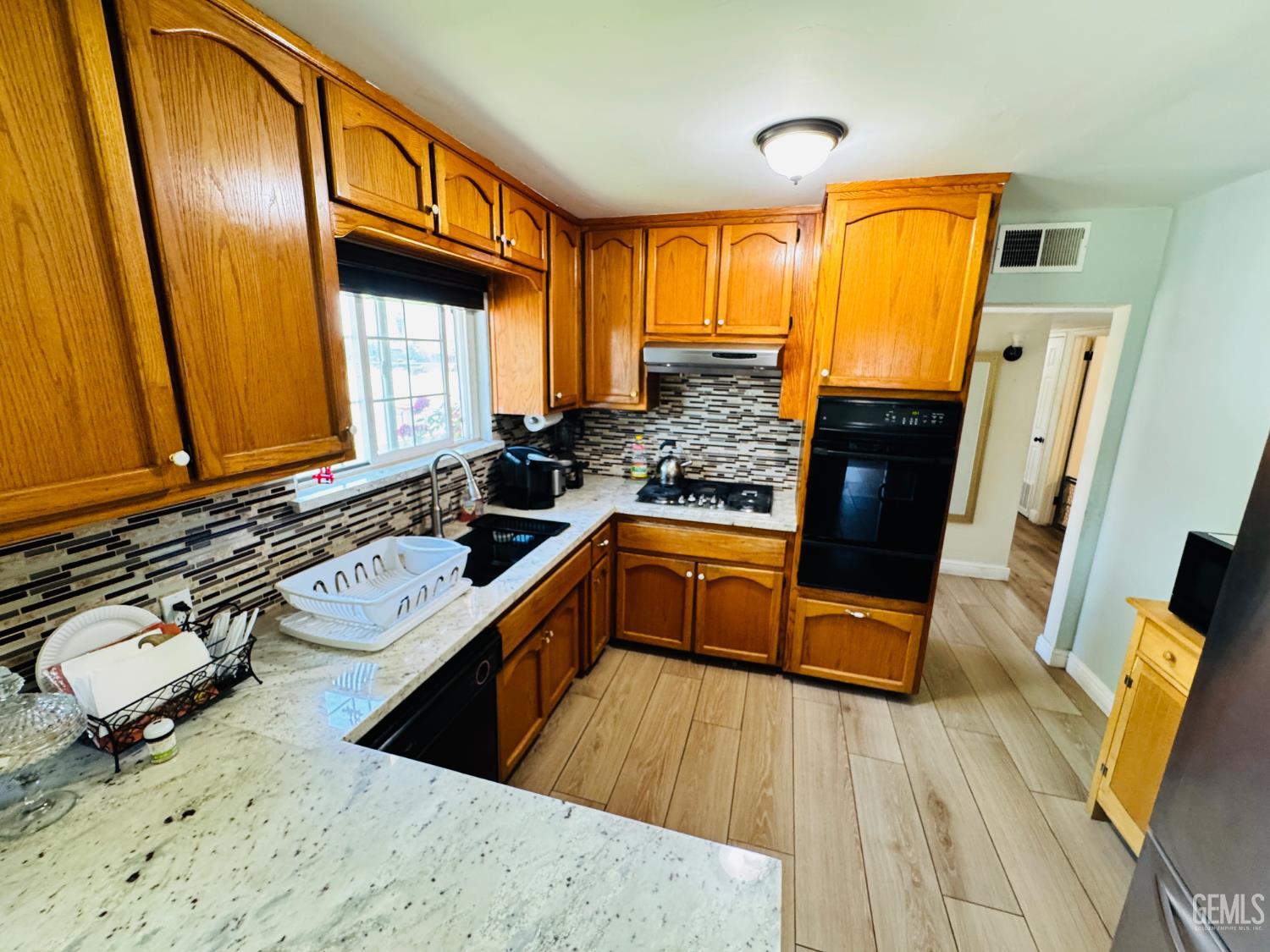 Undisclosed Address Delano, CA 93215 - Photo 10 of 14 a kitchen with wooden floors and a sink