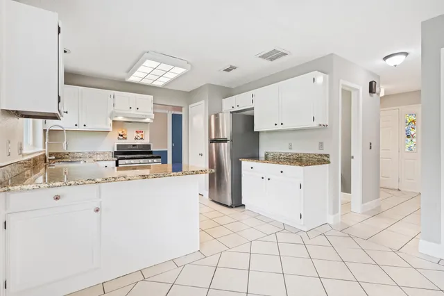 a kitchen with stainless steel appliances granite countertop a stove a sink and a refrigerator