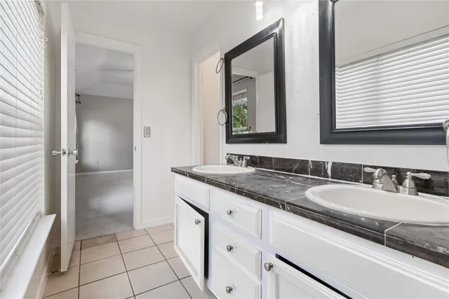 a bathroom with a granite countertop sink and a mirror