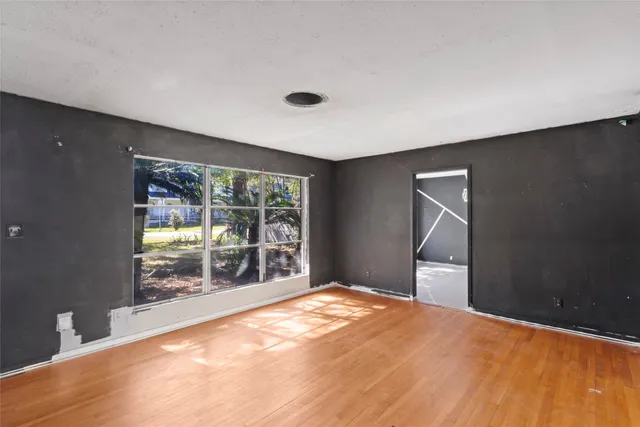a large white kitchen with a large window and refrigerator