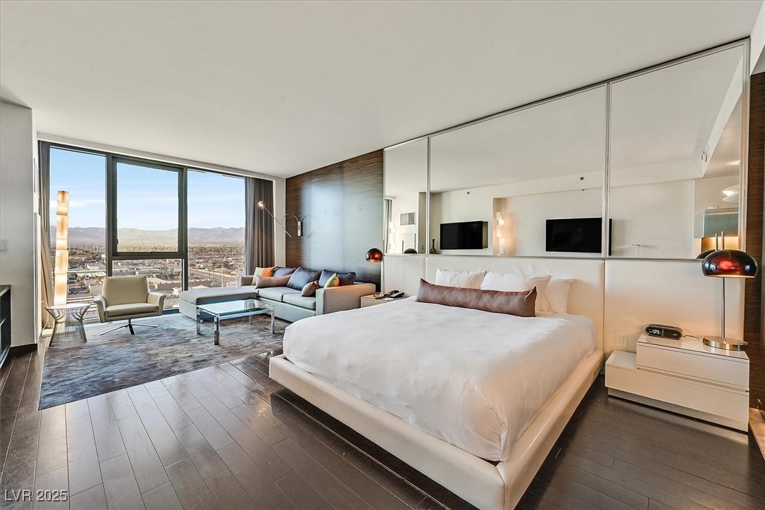 4381 West Flamingo Road, Unit 1609 Las Vegas, NV 89103 - Photo 3 of 27 Bedroom with floor to ceiling windows and dark wood finished floors