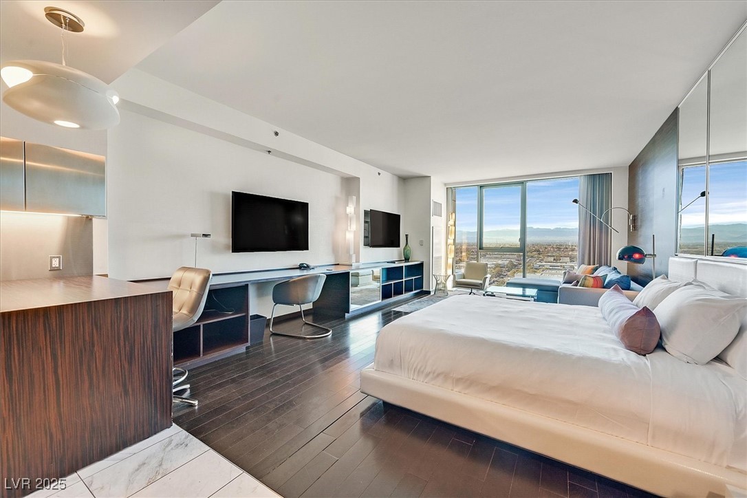 4381 West Flamingo Road, Unit 1609 Las Vegas, NV 89103 - Photo 4 of 27 Bedroom featuring floor to ceiling windows and wood finished floors
