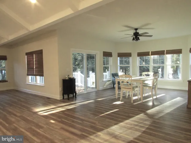 a dining room with wooden floor and chandelier