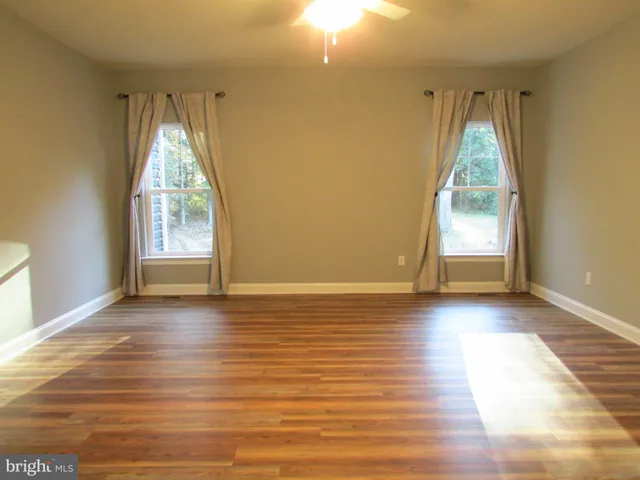 a view of a room with wooden floor and windows