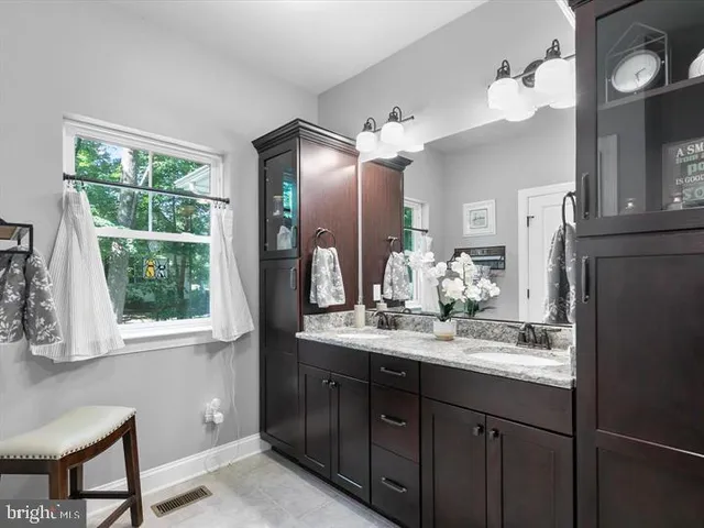 a bathroom with a double vanity sink and a mirror