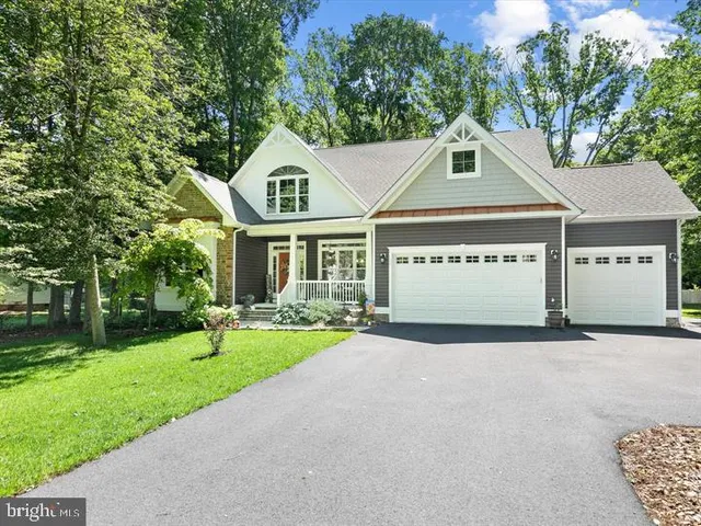 a view of a white house with a big yard and large tree