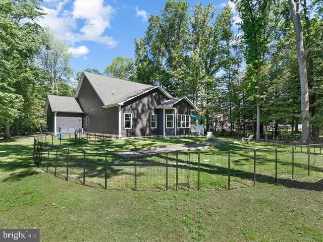 a view of a house with pool and a yard