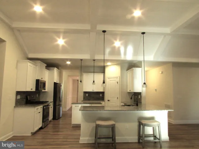 a large white kitchen with a large window and stainless steel appliances