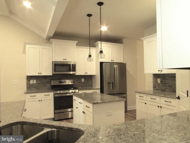 a kitchen with stainless steel appliances a stove sink microwave and refrigerator