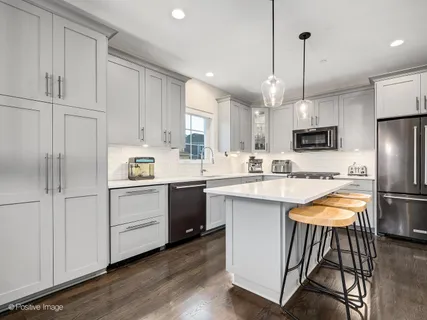 a kitchen with white cabinets and stainless steel appliances